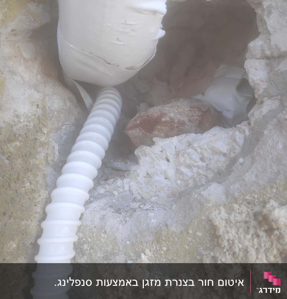 צינור גמיש לבן יוצא מקיר אבן